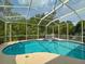 Screened in pool and spa featuring patio space and lush green views for recreation and relaxation at 2349 Wood Pointe Dr, Holiday, FL 34691
