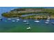 Picturesque aerial view of multiple sailboats near a lush, wooded island in the waterway at 2349 Wood Pointe Dr, Holiday, FL 34691