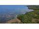 Lush green waterfront on a sunny day featuring clear blue waters and a sandy ocean bottom at 2349 Wood Pointe Dr, Holiday, FL 34691