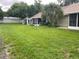 Expansive backyard with lush green grass and a screened-in patio, perfect for outdoor entertaining at 2390 Bentley Dr, Palm Harbor, FL 34684
