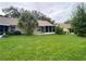 Expansive backyard showcasing lush green lawn and views of the home's exterior at 2390 Bentley Dr, Palm Harbor, FL 34684