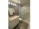Stylish bathroom featuring a granite vanity top, decorative tile accent wall, and glass shower at 2390 Bentley Dr, Palm Harbor, FL 34684