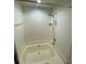 Full bathtub with tile surround and adjustable shower head fixture at 2390 Bentley Dr, Palm Harbor, FL 34684