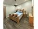 Cozy bedroom features a ceiling fan, wood furniture, and wood-look flooring at 2390 Bentley Dr, Palm Harbor, FL 34684