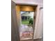 Home's welcoming front entrance featuring a decorative doormat and lush greenery at 2390 Bentley Dr, Palm Harbor, FL 34684