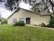 Single story house on a green lawn with a walkway to the front door, flanked by flowering shrubs at 2390 Bentley Dr, Palm Harbor, FL 34684
