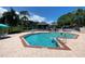Sparkling community pool with clear blue water and ample lounge chairs for relaxation and enjoyment at 2390 Bentley Dr, Palm Harbor, FL 34684