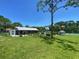 Community pool area featuring a covered pavilion, ample green space, and a gazebo, perfect for relaxation at 2390 Bentley Dr, Palm Harbor, FL 34684