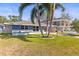 Quaint single-story home with a lush green lawn, palm trees, and a welcoming front entrance at 306 12Th Ave, Indian Rocks Beach, FL 33785