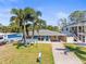 Charming single-story home with a well-manicured lawn, tall palm trees, and a long driveway at 306 12Th Ave, Indian Rocks Beach, FL 33785