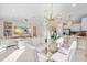 Open concept living and dining area with contemporary furnishings and a glass dining table set for four at 3198 Malta Ave, Wesley Chapel, FL 33543