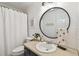 Cozy bathroom featuring a round mirror, vanity, and shower with a white curtain for a fresh, clean look at 3205 W De Leon St # F, Tampa, FL 33609