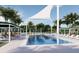 Community pool with white sunshades, surrounding lounge chairs, and greenery for leisure and relaxation at 32523 Neroli St, Wesley Chapel, FL 33543