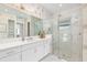 Modern bathroom featuring a glass-enclosed shower, large mirror, and white vanity with ample counter space at 32608 Neroli St, Wesley Chapel, FL 33543