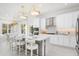 Bright, modern kitchen featuring white cabinets, stainless steel appliances, and a spacious island with seating at 32608 Neroli St, Wesley Chapel, FL 33543