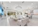 Open-concept living space with sleek furniture, abundant natural light, and a modern kitchen in the background at 32608 Neroli St, Wesley Chapel, FL 33543