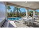 Outdoor patio with a dining area and lounge seating, overlooking a beautiful pool and lush greenery at 32608 Neroli St, Wesley Chapel, FL 33543
