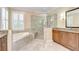 Bright bathroom featuring a soaking tub, glass shower, vanity, and natural light at 3323 Anna George Dr, Valrico, FL 33596