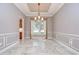 Dining room featuring elegant wainscoting, decorative tile flooring, and modern light fixture at 3323 Anna George Dr, Valrico, FL 33596