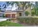 Inviting two-story home with a lush front yard, mature trees, and a spacious three-car garage at 3323 Anna George Dr, Valrico, FL 33596
