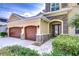 Home exterior with a two-car garage, stone accents, and manicured landscaping at 3323 Anna George Dr, Valrico, FL 33596