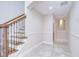 Bright hallway featuring a staircase with decorative railing, updated tile floors, and recessed lighting at 3323 Anna George Dr, Valrico, FL 33596
