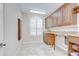 Laundry room featuring tile floor, granite countertop, laundry sink, and wooden cabinets at 3323 Anna George Dr, Valrico, FL 33596