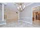 Spacious living room with elegant chandelier, beautiful tile floors, and views into the kitchen at 3323 Anna George Dr, Valrico, FL 33596