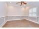 The Living room showcases wainscoting, a modern ceiling fan, and a large window with plantation shutters at 3323 Anna George Dr, Valrico, FL 33596