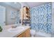 The bathroom is adorned with a blue patterned shower curtain and a decorative wood shelving unit at 3456 Castle Stone Ct, Valrico, FL 33594