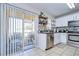 This kitchen features stainless steel appliances, white cabinets, and sliding doors to the screened patio at 3456 Castle Stone Ct, Valrico, FL 33594