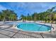 Community pool area surrounded by lounge chairs and lush landscaping, perfect for relaxation and recreation at 3456 Castle Stone Ct, Valrico, FL 33594
