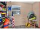 A garage wall with a window, ladder, shelving, cleaning supplies, and other items creating a functional space at 3501 63Rd N St, St Petersburg, FL 33710