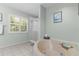 Bathroom featuring soaking tub, shower, tile floors, and natural light at 3668 Pond View Ln, Sarasota, FL 34235