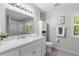 Bathroom with white vanity, updated fixtures, tiled floors and ample natural light at 3668 Pond View Ln, Sarasota, FL 34235