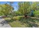 Well-maintained front yard with lush landscaping and mature trees providing shade at 3668 Pond View Ln, Sarasota, FL 34235