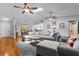 Open concept living room features wood floors, skylight, ceiling fans, and lots of natural light at 3668 Pond View Ln, Sarasota, FL 34235