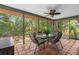 Enclosed outdoor patio featuring tile floor, table, and fan, perfect for outdoor dining at 3668 Pond View Ln, Sarasota, FL 34235
