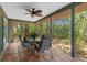 Comfortable screened patio with ceiling fan overlooking lush, tropical landscaping at 3668 Pond View Ln, Sarasota, FL 34235