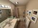 Neutral-toned bathroom features a shower-tub combo and decorative coastal artwork and décor at 37401 Teaberry Loop, Zephyrhills, FL 33542