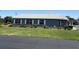 Single-story home with an American flag flying, landscaped yard, and bright windows with shutters at 37401 Teaberry Loop, Zephyrhills, FL 33542