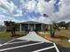 Charming single-story home with an American flag, palm trees and well-manicured landscaping at 37401 Teaberry Loop, Zephyrhills, FL 33542