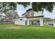 Lush green backyard featuring a modern home with a covered patio and balcony, perfect for outdoor relaxation and entertainment at 3817 W San Nicholas St, Tampa, FL 33629