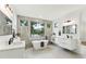 Bright bathroom with double sinks, a soaking tub, and a large window with a treeline view at 3817 W San Nicholas St, Tampa, FL 33629