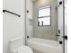 Modern bathroom featuring a tub, glass shower door, shower niche, and black fixtures for a sleek design at 3817 W San Nicholas St, Tampa, FL 33629