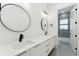 Modern bathroom features dual sinks, quartz countertops, black fixtures, and stylish mirrors with a view of the shower at 3817 W San Nicholas St, Tampa, FL 33629