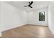 Modern bedroom with light wood flooring, white walls, and a black ceiling fan at 3817 W San Nicholas St, Tampa, FL 33629