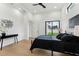 Stylish bedroom with hardwood floors, a sleek metal bed, and a sliding glass door to a private backyard at 3817 W San Nicholas St, Tampa, FL 33629