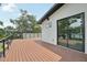 Large wooden deck area with metal railing, providing outdoor entertainment space with a view of the backyard and trees at 3817 W San Nicholas St, Tampa, FL 33629