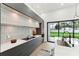 Open-concept kitchen featuring modern appliances, sleek cabinets, and access to the outdoor area at 3817 W San Nicholas St, Tampa, FL 33629